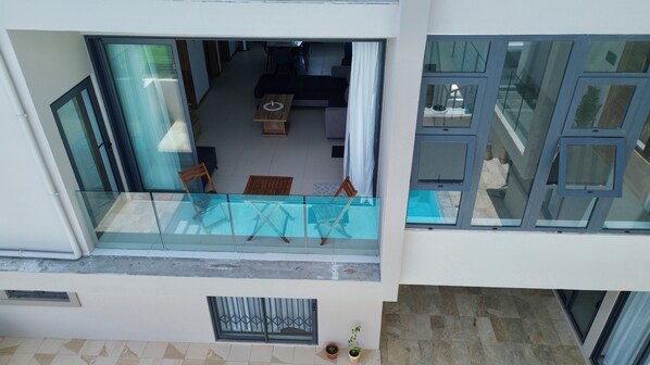 A modern apartment with a glass balcony, a dining area, and a living room. - Lovely 2-bedroom apartment with lift, swimming pool in Grand Baie (Grand Baie)