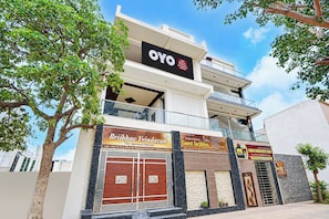 A multi-story building with a prominent sign for 'OYO Hotel Brijbhav Vridavan The Spiritual Retreat' and additional signage for guest facilities. - Hotel O Brijbhav Vrindavan The Spiritual (Vrindavan)