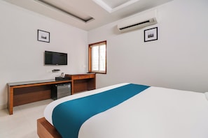 A hotel room with a bed, a desk with a chair, a television, and an air conditioning unit. - Hotel O Stay Inn Maharani Peta (Visakhapatnam)