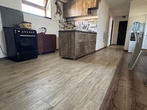 A kitchen with a wooden floor, a stove, and a refrigerator. - Spacious Garden-Level Apartment with Ararat Views (Kotayk)