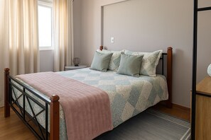 Une chambre à coucher avec un lit en bois, une couvre-lit matelassée et une table de chevet avec une lampe.