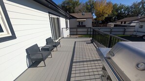 Eine Terrasse mit Gartenmöbeln und Grill.