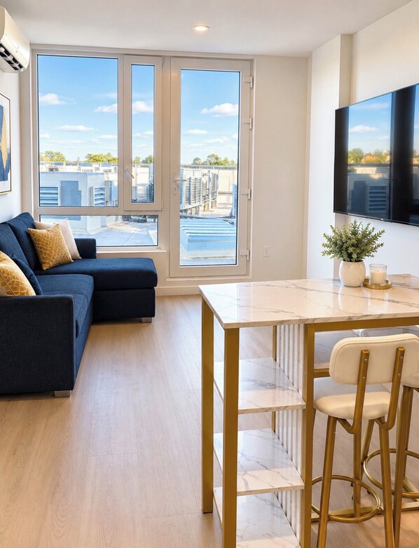 Un salon moderne avec un canapé, une table à manger et un téléviseur.
