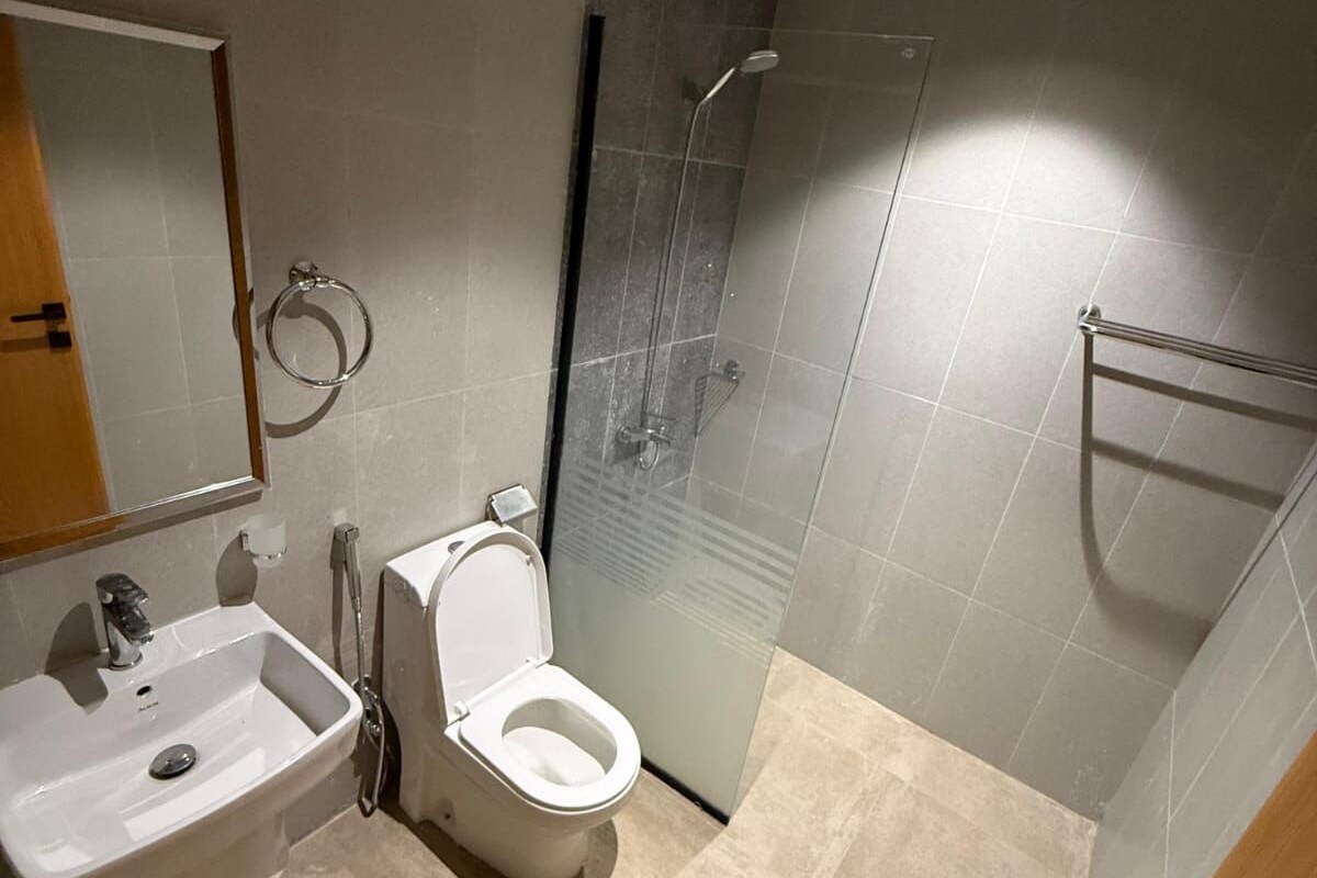 Un baño moderno con lavamanos, inodoro y cabina de ducha de vidrio.