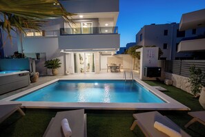 A modern residential building with a swimming pool, outdoor furniture, and a well-maintained garden. - Apartment Simba with Private Heated Pool & Jacuzzi (Novalja)