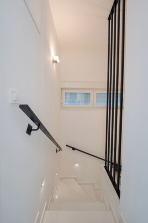 A staircase with a handrail, a light switch, and a window with blinds. - Apartment Simba with Private Heated Pool & Jacuzzi (Novalja)