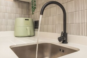 Un évier de cuisine doté d’un robinet moderne et d’une machine à café intégrée.