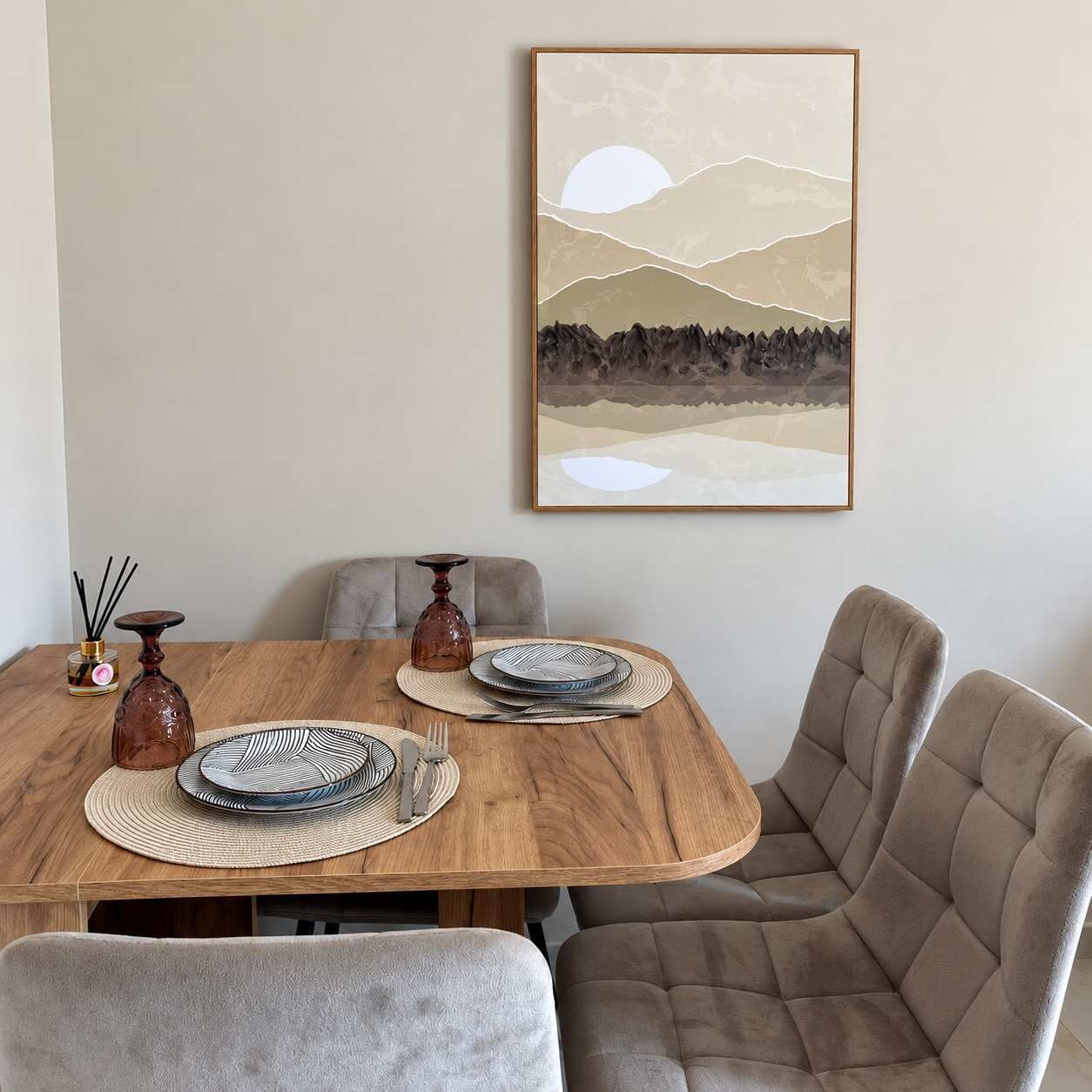 Ein Essbereich mit einem Holztisch, gedeckt für zwei Personen, einem gerahmten Landschaftsbild an der Wand und einer Vase mit einer Kerze.
