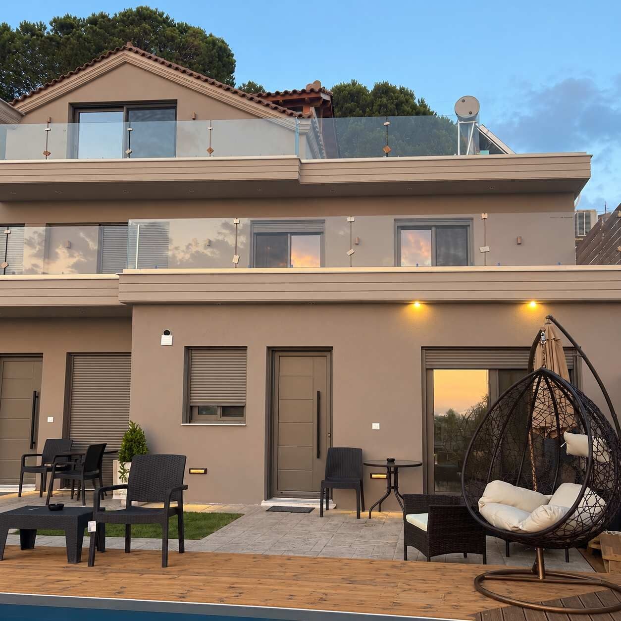 Ein zweistöckiges Gebäude mit Balkon, Sitzbereich im Freien und Pool.