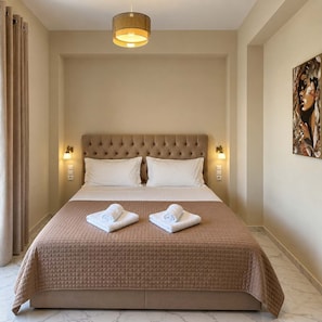 Una habitación de hotel con una cama grande, un cabecero, dos lámparas de pared y un cuadro en la pared.