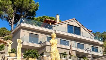 Un immeuble à plusieurs étages, doté d’une façade en pierre, de balcons et de statues extérieures.