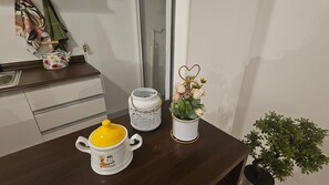 A kitchen counter with a yellow pot, a white ceramic container, and a vase with flowers. - New Listing (Villarrica)