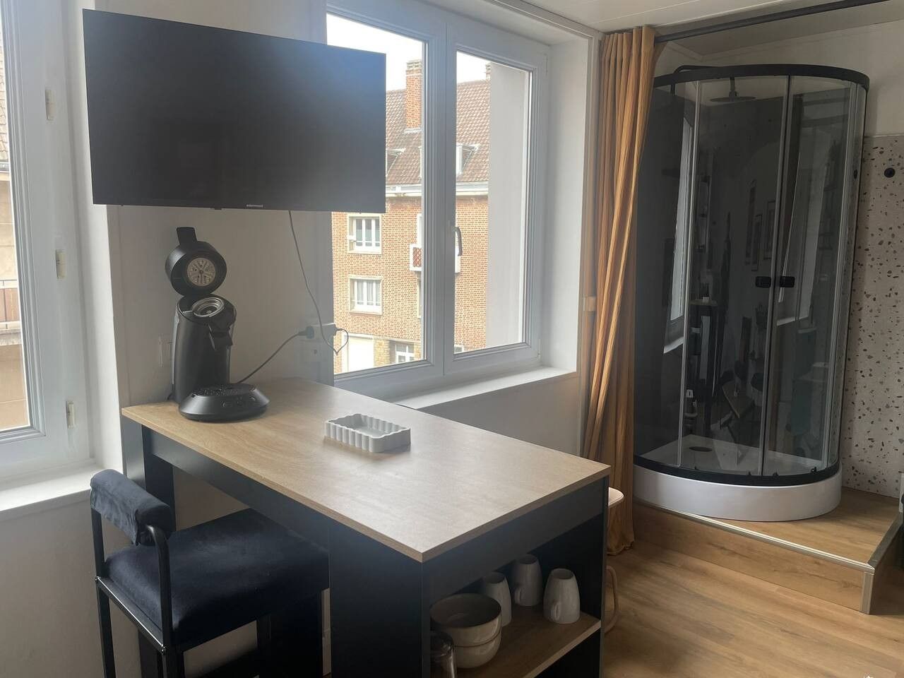 Une chambre équipée d’un bureau, d’une chaise et d’un espace douche.