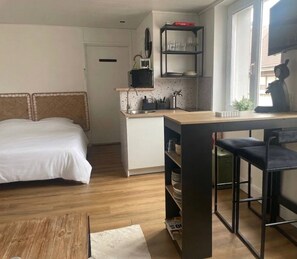 Ein kleiner Raum mit Bett, einer Küchenzeile und einem Essbereich.