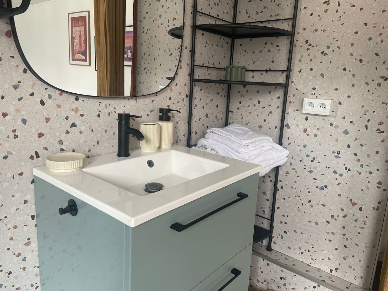 Ein Badezimmer mit Waschbecken, Spiegel und Handtuchhalter.