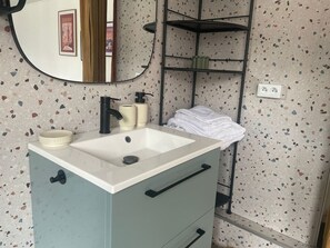 Ein Badezimmer mit Waschbecken, Spiegel und Handtuchhalter.