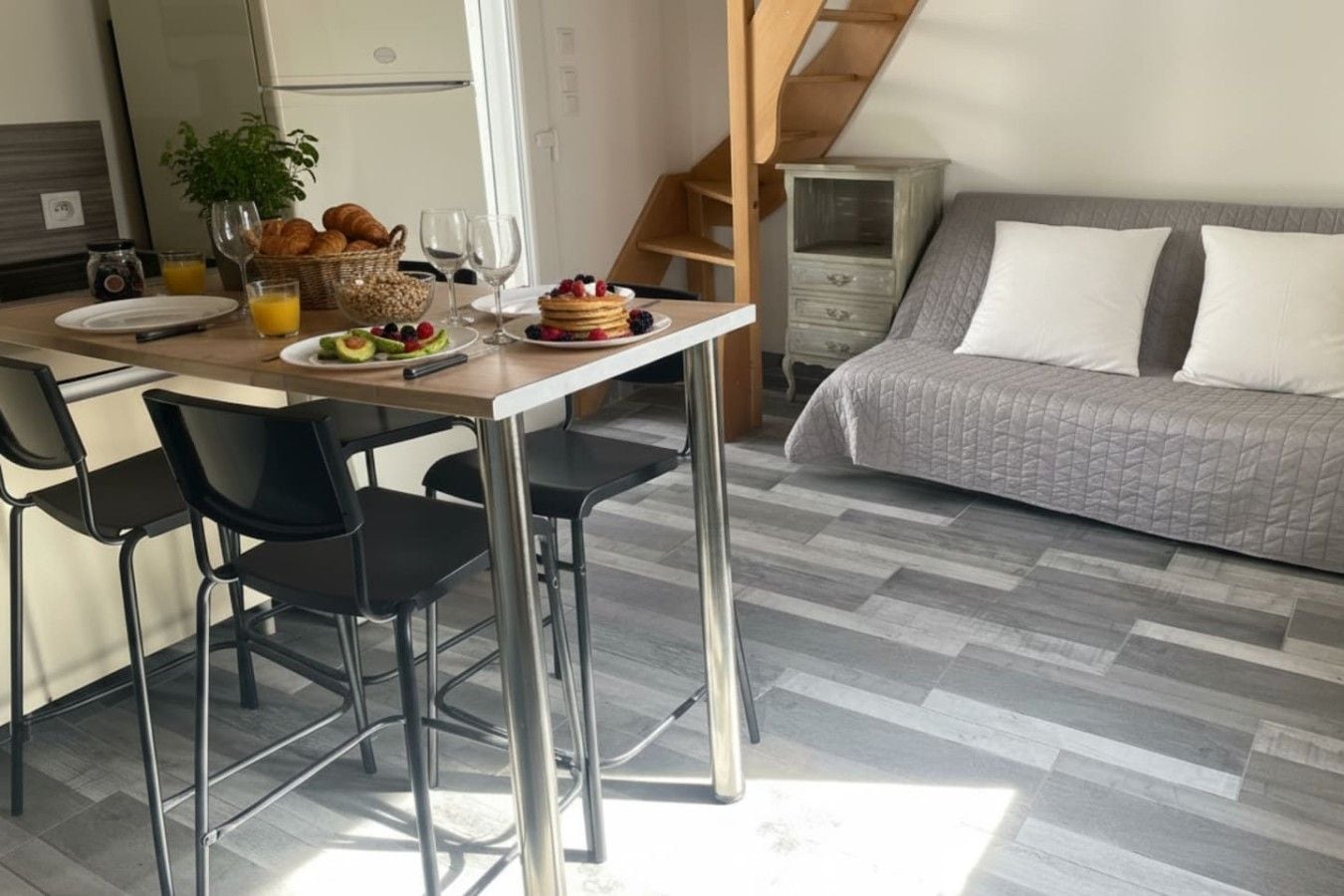 Une cuisine moderne avec une table à manger, des chaises et des aliments pour le petit-déjeuner.