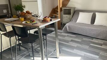 Une cuisine moderne avec une table à manger, des chaises et des aliments pour le petit-déjeuner.