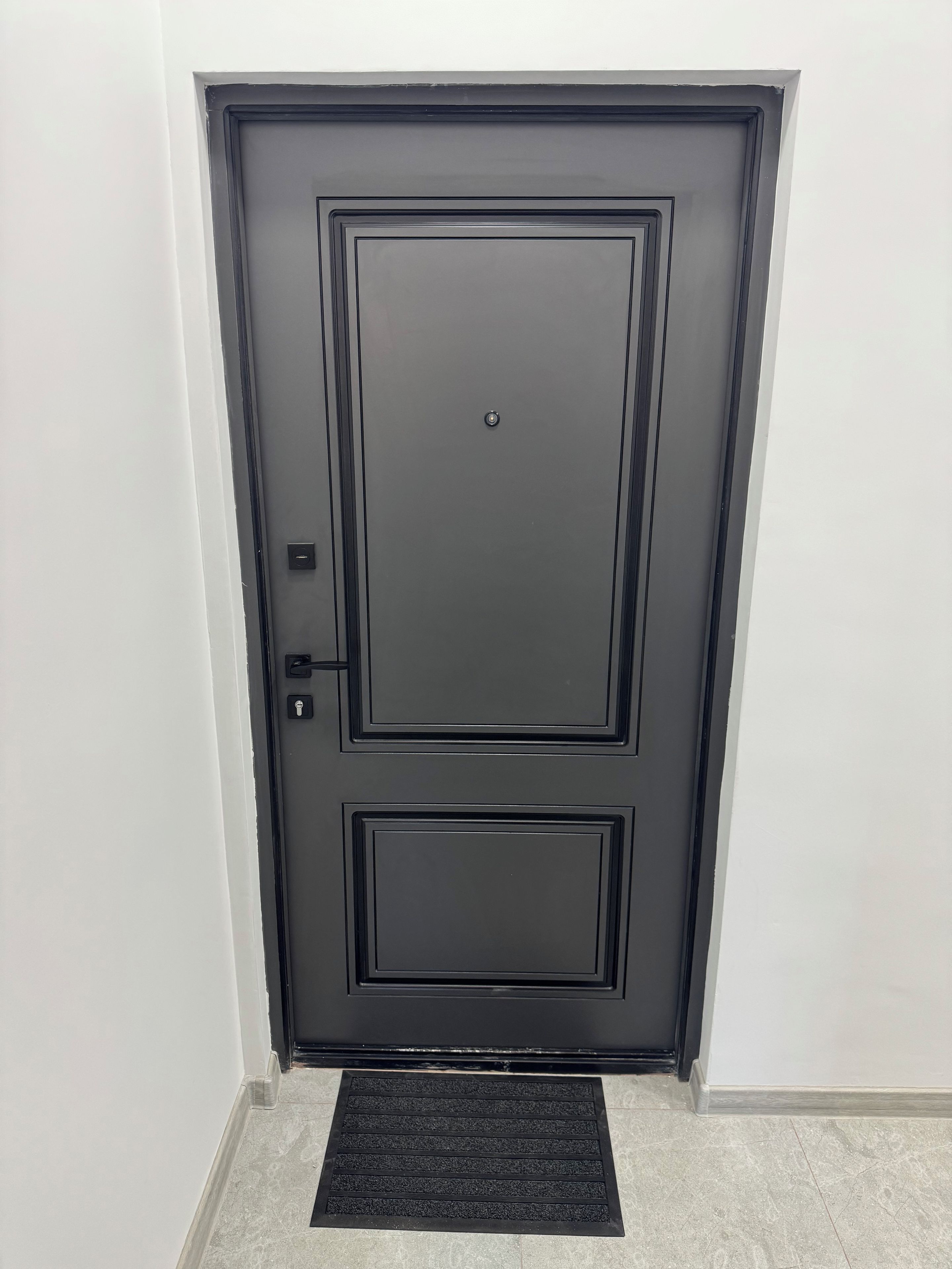 Una porta nera con una serratura e un piccolo chiavistello sul lato sinistro.