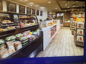 Zona de exhibición de alimentos con distintos productos y un cartel de menú al fondo.