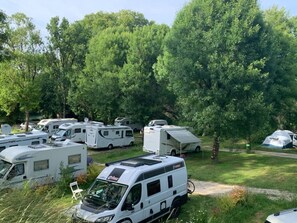 En campingplats med flera husbilar parkerade bland träden.