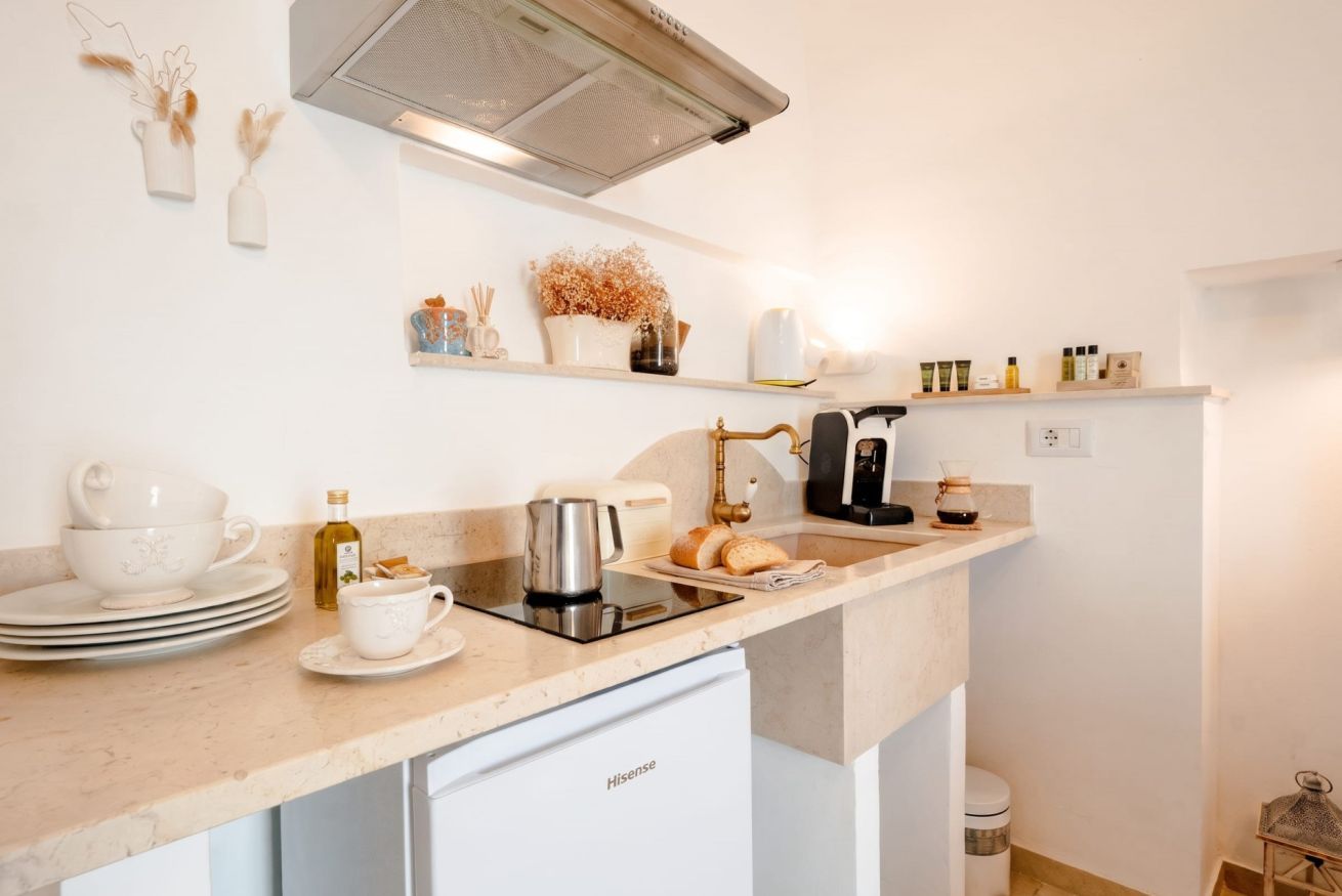 Una cocina moderna equipada con lavavajillas, cafetera y diversos utensilios de cocina.