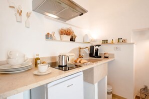 Una cuina moderna amb rentaplats integrat, cafetera i diversos utensilis de cuina.