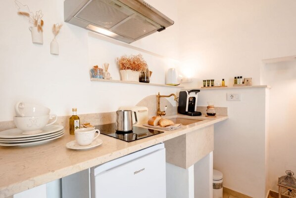A modern kitchen with a built-in dishwasher, a coffee maker, and a variety of kitchenware. - La Dimora del Faro | Elegant Suite with Whirlpool Bath (Bari)