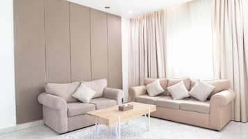 A modern living room with two sofas, a coffee table, and a patterned rug.