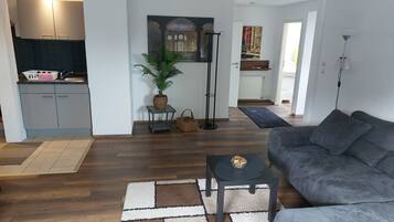 Un salon moderne avec un canapé gris, une table basse et un tapis à motifs.