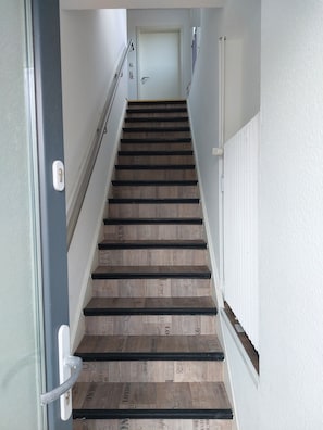 A staircase with wooden steps and metal handrails, leading to a door at the top. - Quiet self-contained apartment with terrace and parking (Heide)