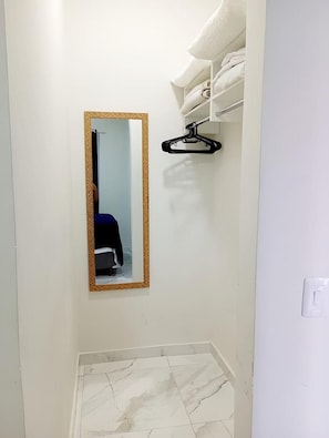 Une salle de bain avec un miroir, un porte-serviettes et un sol carrelé.