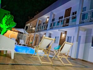 A multi-story hotel with a pool area, outdoor seating, and a well-lit balcony. - New Listing (Vila Velha)