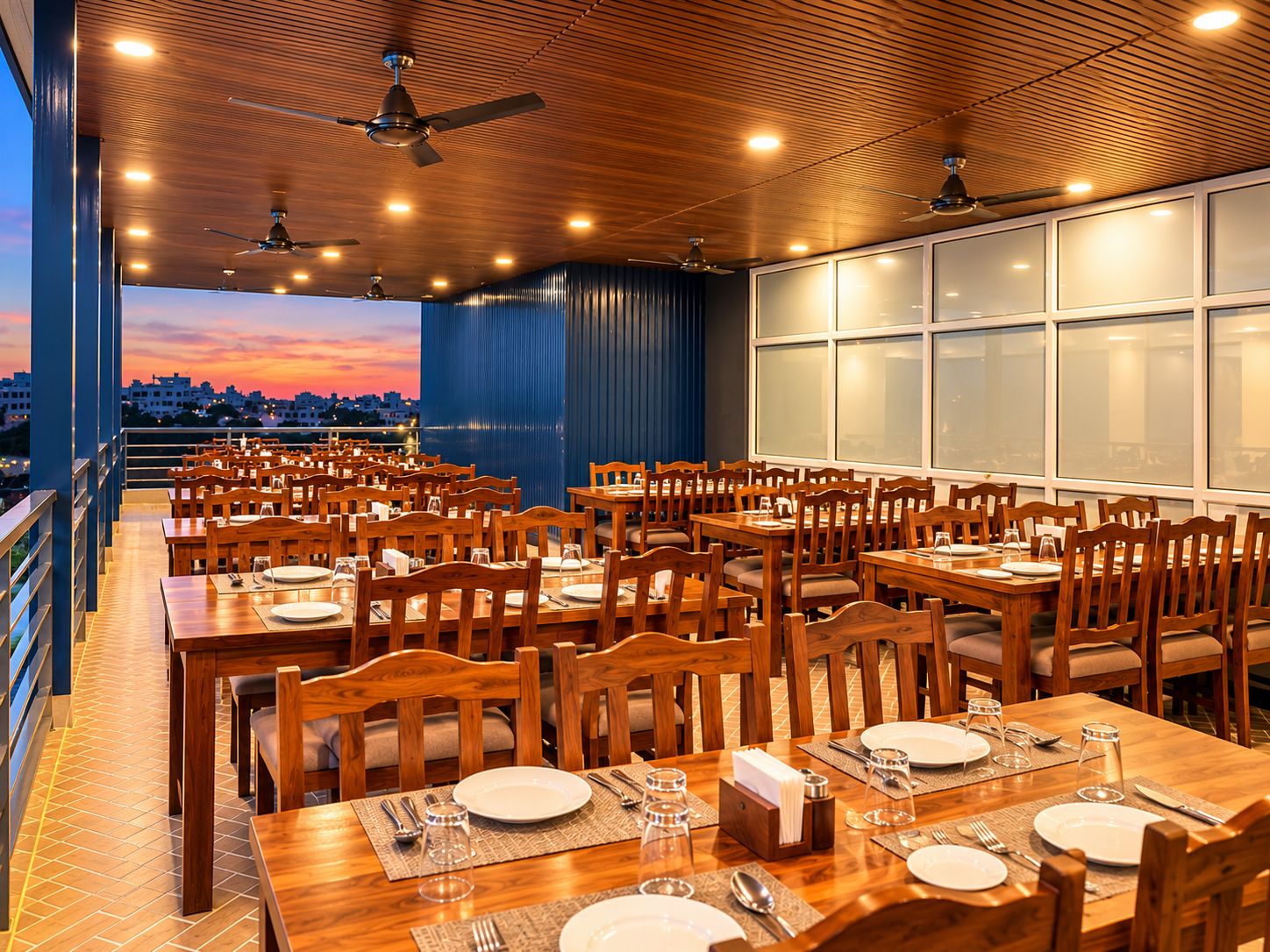 A restaurant with multiple tables and chairs, ceiling fans, and large windows.