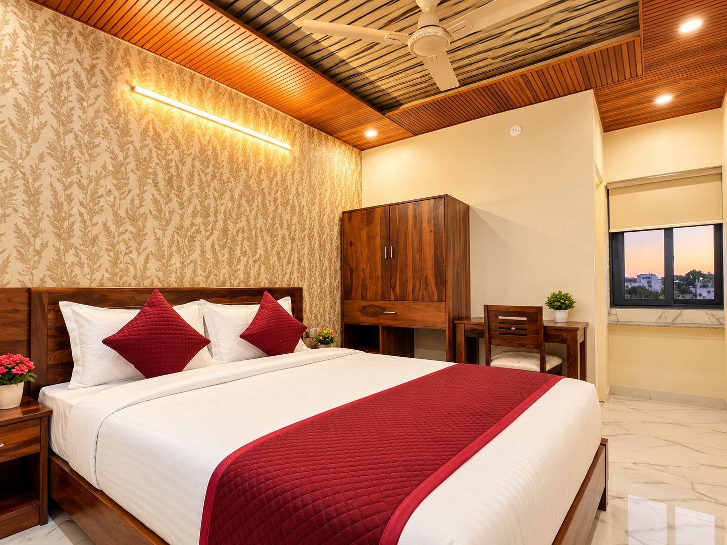 Habitación de hotel con cama, cabecero de madera, armario, escritorio, silla, ventana con vistas y ventilador de techo.
