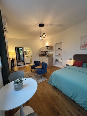 A modern bedroom with a bed, a dining table with chairs, a kitchen area, and a seating area with a sofa and chairs. - New Listing (L'Union)