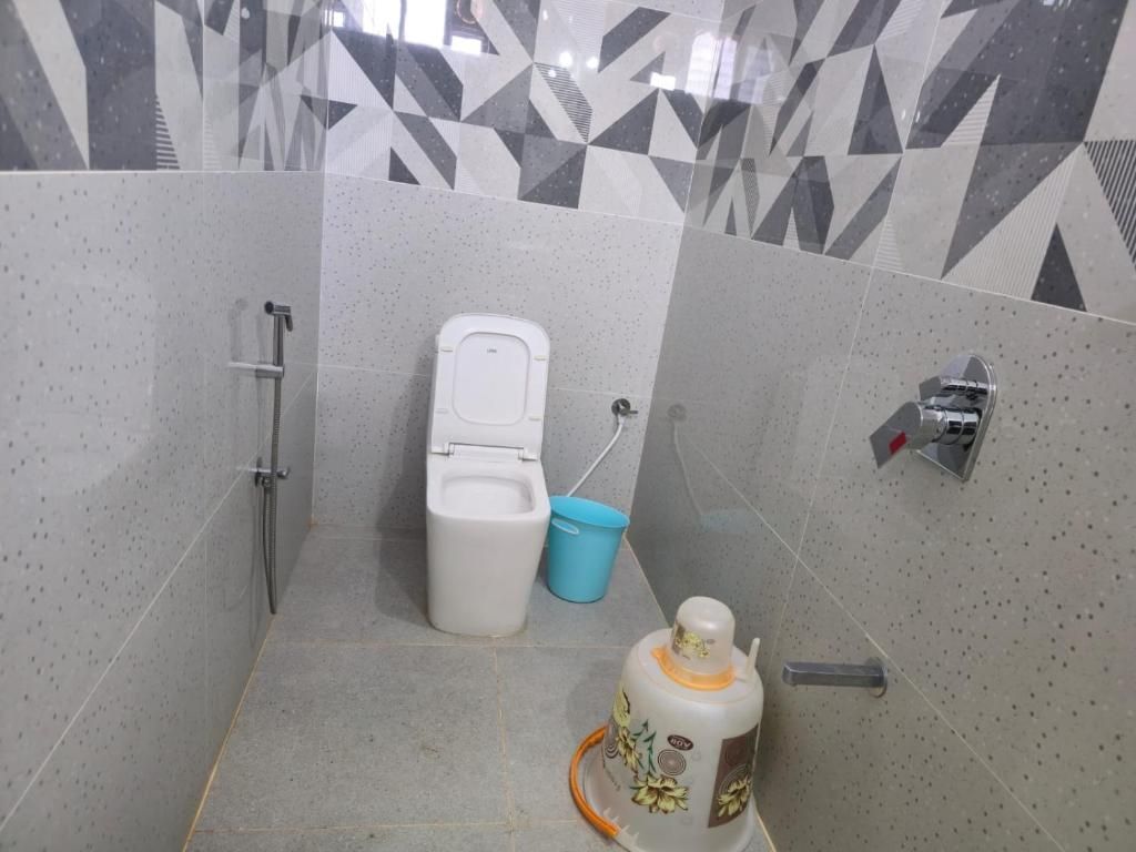 A bathroom with a toilet, a shower, and a sink.