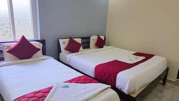 Two single beds with white and red bedding, a window with a view, and an air conditioning unit on the wall.