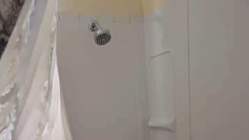 A bathtub with a showerhead, a faucet, and a drain.