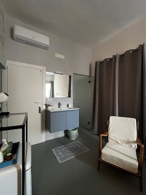 A hotel room with a bathroom, a chair, a sink, and a mirror. - Room 'Pepenero Apulian Rooms - Loggetta' with Wi-Fi and Air Conditioning (Noci)