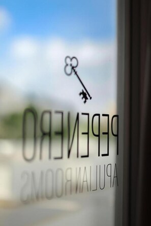 A key symbol above the text 'PEREIRO' and 'PEREIRO'S' on a window, indicating a hotel or property name. - Room 'Pepenero Apulian -Pietra Viva' with Wi-Fi and Air Conditioning (Noci)