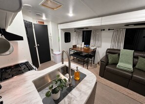 Un espace de vie compact comprenant une cuisine, un coin repas et un canapé.