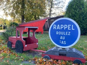 Un tren de juguete rojo y un letrero con el texto 'Rappel Roulette AU FAS'.
