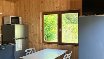 L’intérieur d’une cabine comprend un coin cuisine équipé d’un réfrigérateur, d’un four à micro-ondes et d’une table avec des chaises.
