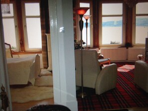 A room with a red plaid carpet, a lamp, and a view of the sea through large windows. - Stunning sea views and scenic walks (Kirn)