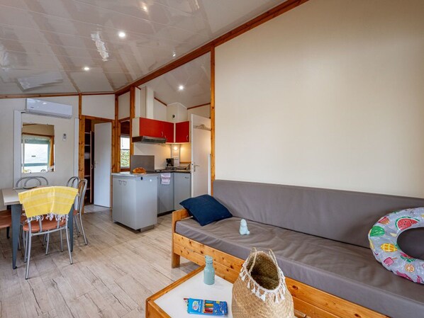 A compact living space with a kitchenette, a dining area, and a sofa. - Chalet, pets OK, AC - 8 guests (Badefols-sur-Dordogne)