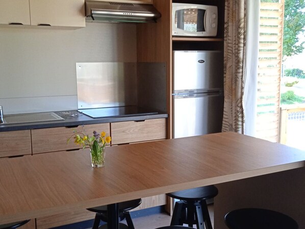 A modern kitchen with a wooden countertop, stainless steel appliances, a microwave, and a refrigerator. - Chalet pets welcome - 7 guests (Pleaux)