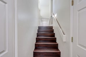 Una escalera de madera con peldaños que conducen a una puerta en la parte superior.