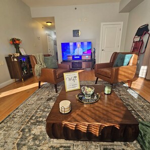 A living room with a TV, two sofas, a coffee table, and a rug. - Spacious Boston 3BR 1 BATH, Private Porch, WiFi & In-Unit Laundry (Boston)