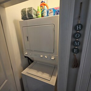Une petite buanderie grise, équipée d’un lave-linge et d’un sèche-linge.